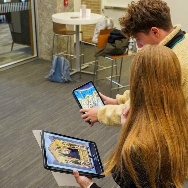 Two students in a Medieval-Renaissance Italian Literature and Culture course look at artwork on tablets in an augmented reality component of an XR experience.