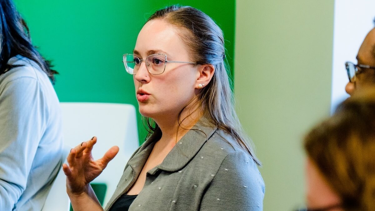 a woman sitting in a conference room makes a comment