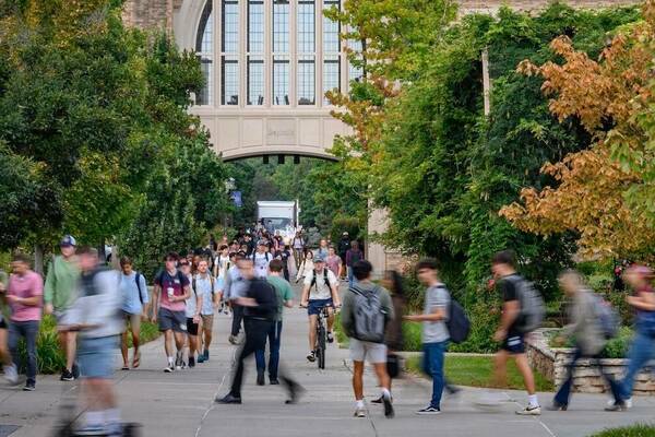 a large number of students walking to class on the Notre Dame campus