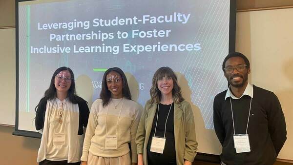 Four presenters smile in front of a projected screen with the title "Leveraging Student-Faculty Partnerships to Foster Inclusive Learning Experiences." The screen displays a stylized graphic of the University of Notre Dame campus.