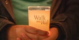 closeup of hands holding a Walk the Walk Week votive candle